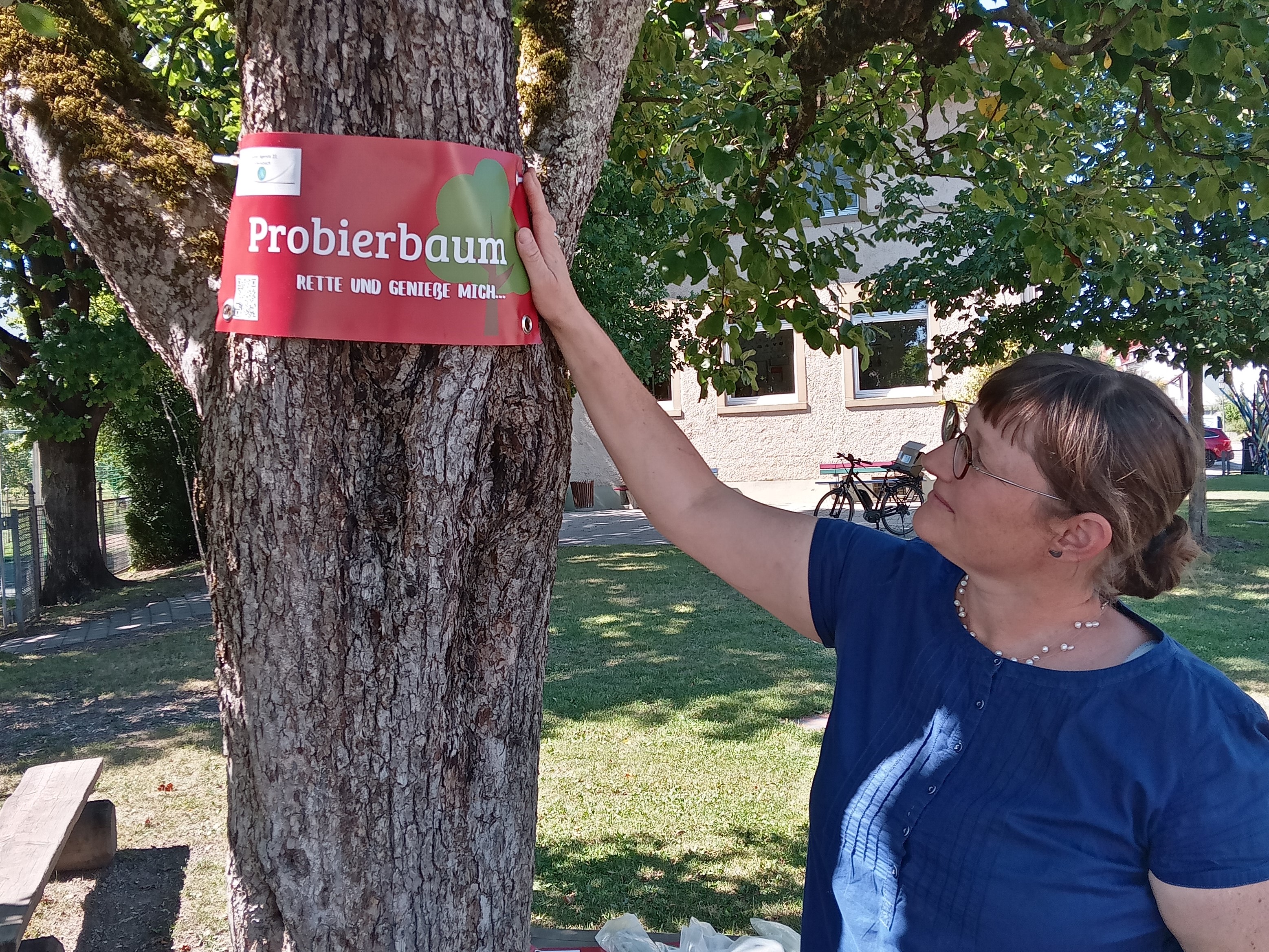 Frau zeigt auf Probierbaumschild - Foto: Lokale Agenda 21 