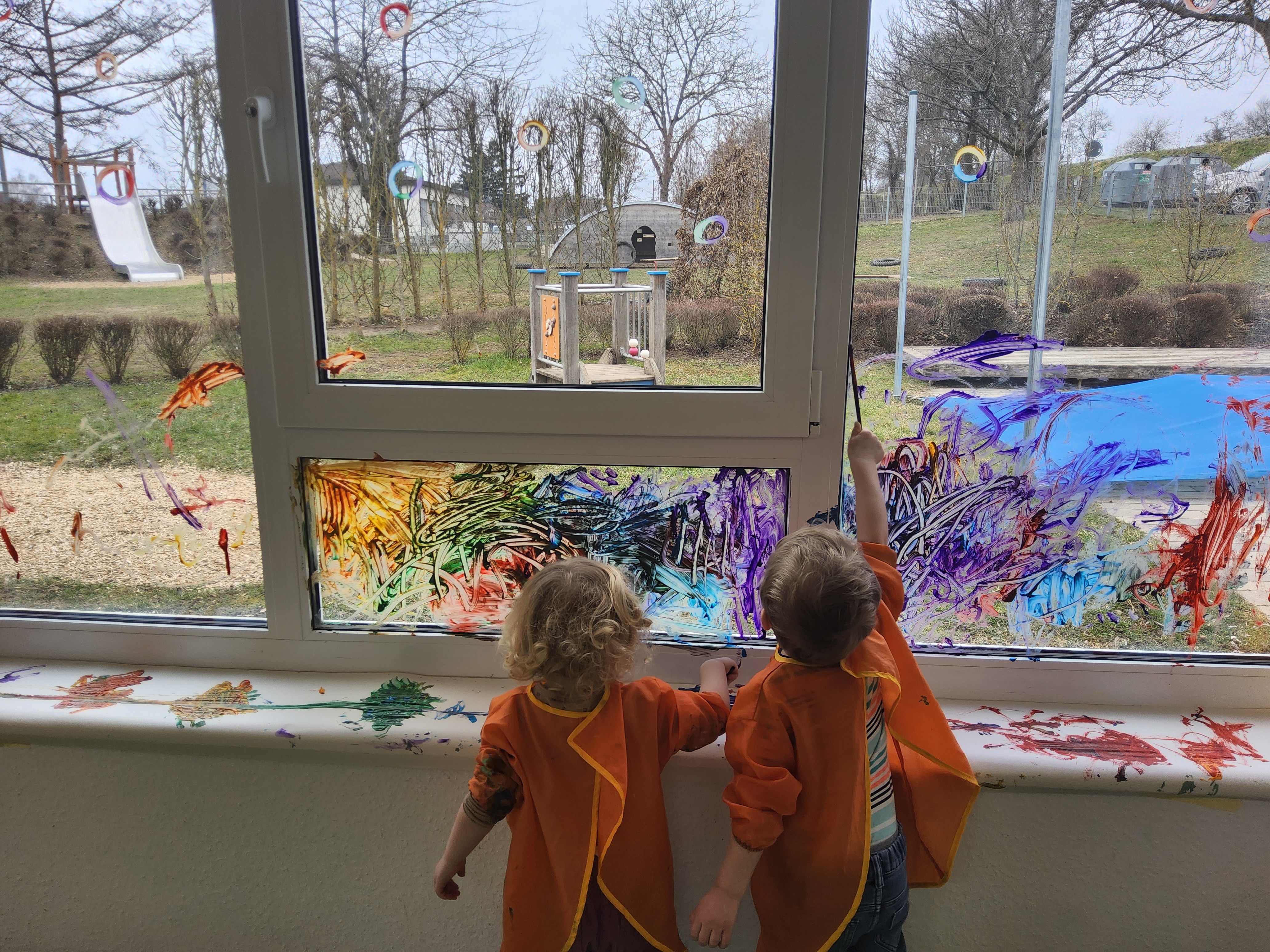  Kinder malen am Fenster 